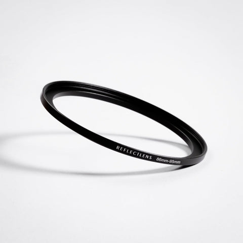 Black threaded lens-filter adapter ring on a light background
