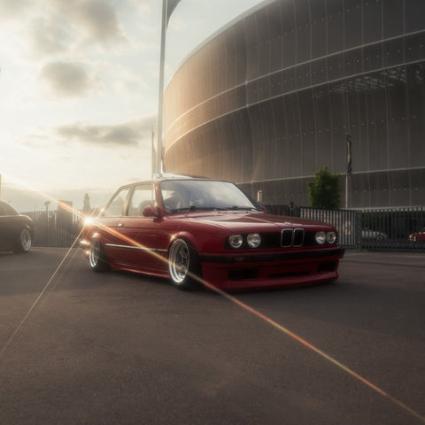 Red classic car beside a curved building in a warm Nebula Flare automotive photograph