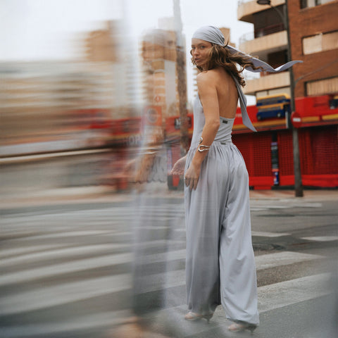 Woman in a grey outfit and headscarf on a city street, with horizontal ghosting extending to the left